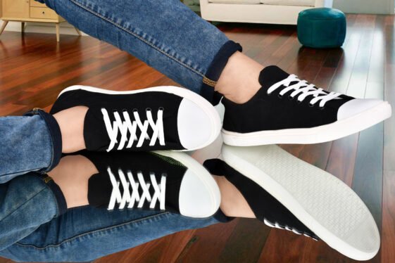 Sleek black canvas sneakers with white laces and a contrasting white sole, styled with blue denim jeans, displayed on a reflective surface. #black #blacklove #blacksneakers #buyblack #buynow #lowprice