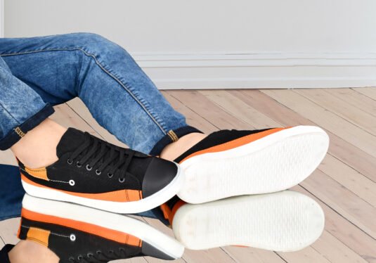 Men's lightweight canvas sneakers in black and orange, designed for casual, everyday comfort with breathable fabric and cushioned soles.